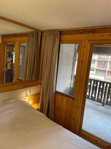 une chambre avec un lit et une grande fenêtre dans l'établissement Central 3 bedroom chalet with balcony, à Val dʼIsère
