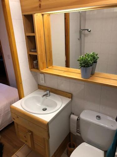 une salle de bain avec un lavabo, des toilettes et un miroir dans l'établissement Central 3 bedroom chalet with balcony, à Val dʼIsère