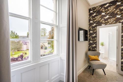 a room with a window and a chair in front of it at The Woodside in Doune