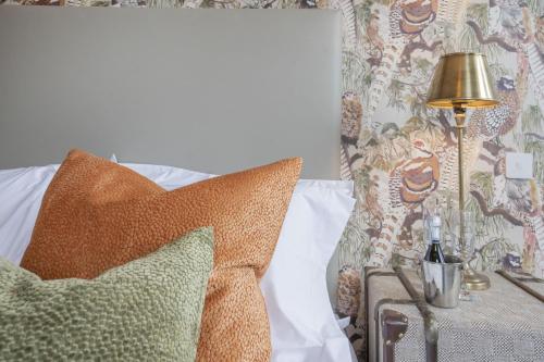 a bedroom with a bed with pillows and a lamp at The Woodside in Doune