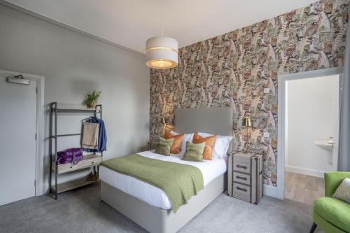 a bedroom with a bed and a wall covered in wallpaper at The Woodside in Doune