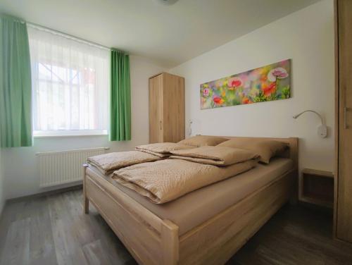 1 dormitorio con 1 cama con cortinas verdes y ventana en Ferienwohnungen MAXIMA en Bad Arolsen