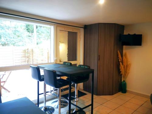 une salle à manger avec une table et des chaises noires dans l'établissement Le Cosy de l'île, à Avignon