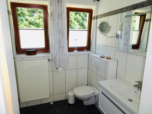 a white bathroom with a toilet and a sink at Ferienhaus Lebenskraft in Pfaffetschlag