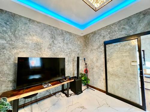 a living room with a large flat screen tv at Chill at Hill Pool Villa Sattahip in Ban Tao Than
