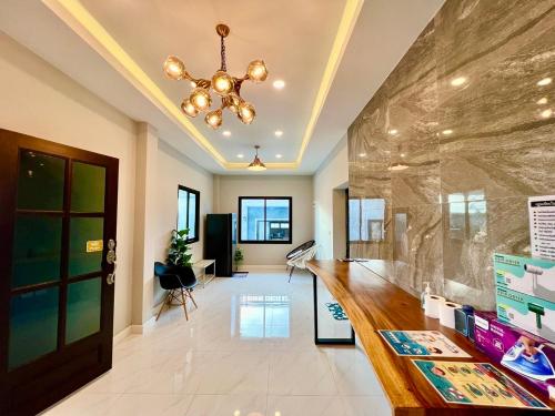 a lobby with a large stone wall and a chandelier at Chill at Hill Pool Villa Sattahip in Ban Tao Than
