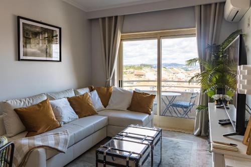 a living room with a couch and a large window at River 9 and City View Porto Gaia by MP in Vila Nova de Gaia