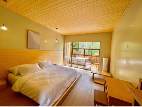 a bedroom with a large white bed and a table at Kireina Genting Villa in Genting Highlands