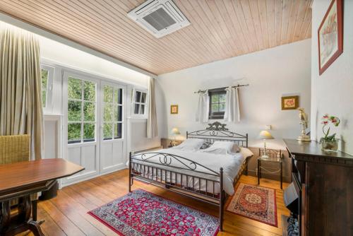 a bedroom with a bed and a desk and a table at Hotel Kasteelhof 'T Hooghe in Ypres