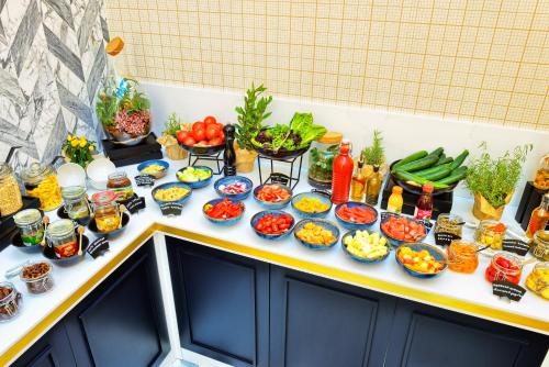 a table topped with bowls of vegetables and other foods at Hotel Ferreus Modern Art Deco in Kraków