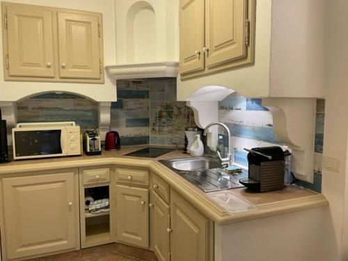 a kitchen with a sink and a microwave at Domaine des Tuilières avec Jacuzzi in Vallauris