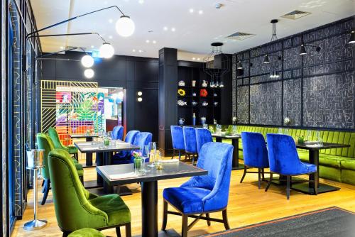 a restaurant with blue chairs and tables at Hotel Ferreus Modern Art Deco in Kraków