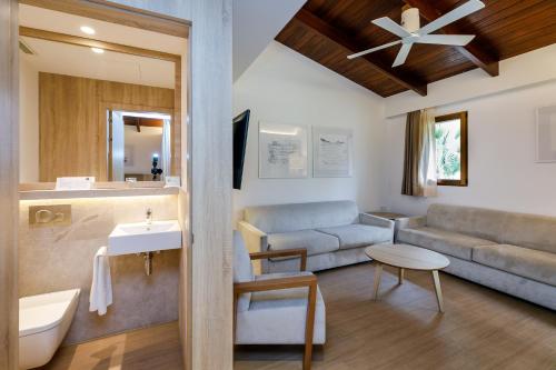 un bagno con divano e un soggiorno con lavandino di PortBlue Club Pollentia Resort & Spa a Alcudia