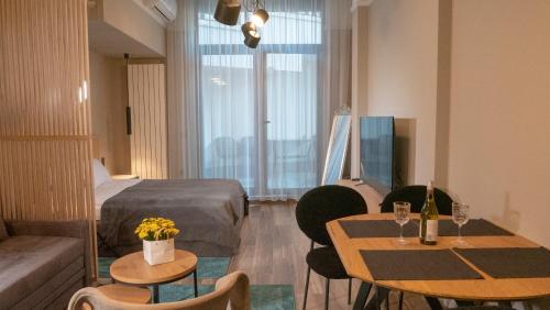 ein Hotelzimmer mit 2 Tischen und einem Bett in der Unterkunft Луксозно студио One Place in Sofia A1 - Лозенец in Sofia