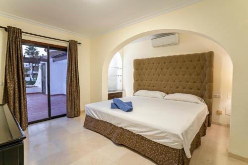 a bedroom with a large bed and a balcony at Apartamentos Albatros Golf del Sur Tenerife in San Miguel de Abona