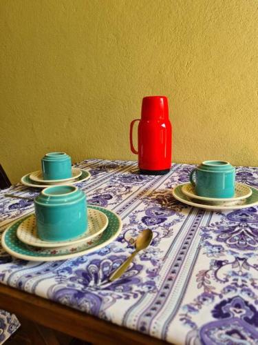 a table with three cups and saucers on it at Pássaros do Cerrado Suítes in Alto Paraíso de Goiás
