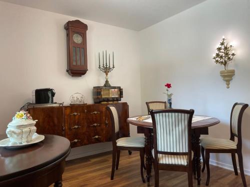 a dining room with a table and a clock on the wall at Iasskii Torg - La belle epoque in Iaşi