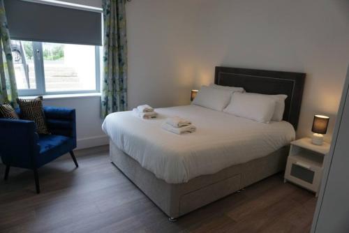 a bedroom with a large bed and a blue chair at Bluestack View Apartment in Donegal