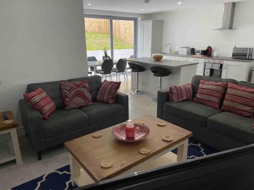 a living room with two couches and a table at Bluestack View Apartment in Donegal