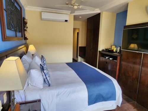a hotel room with a bed and a television at Hotel Casa do Amarelindo in Salvador