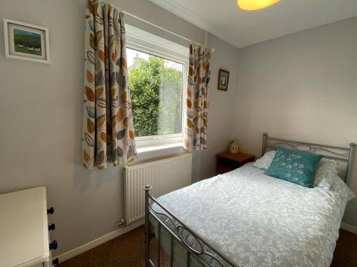 a bedroom with a bed and a window at Ty Nain, Newport, Pembrokeshire in Newport Pembrokeshire