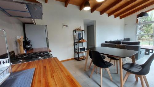 a kitchen and living room with a table and chairs at Alojamiento Chacra El Monje in El Hoyo