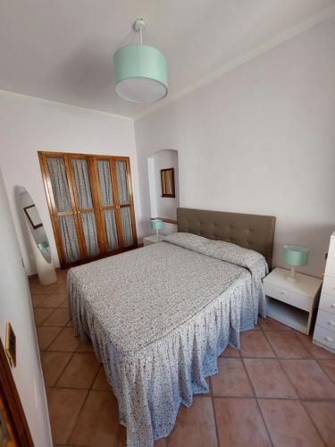 um quarto com uma cama num quarto branco em Appartamento da Rossella em Maratea