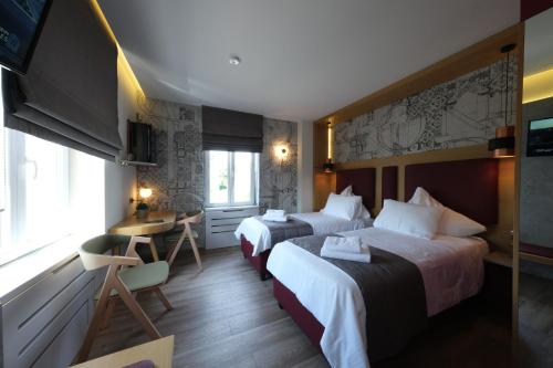 a hotel room with two beds and a desk at Hotel-Restaurant Axion in Weil am Rhein