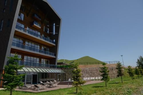 a building with tables and chairs in front of it at Gudauri Lodge in Gudauri