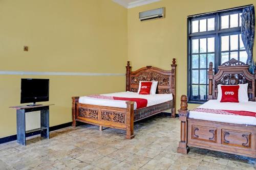 SPOT ON 91798 Hotel Grand Mutiara tesisinde bir odada yatak veya yataklar
