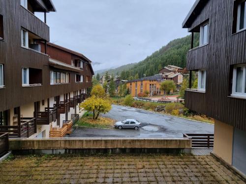 a car parked in a parking lot between two buildings at le Sorbier E La Foux d'Allos in Allos