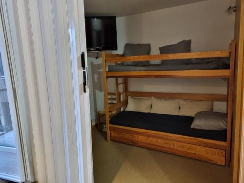 a room with two bunk beds and a television at le Sorbier E La Foux d'Allos in Allos