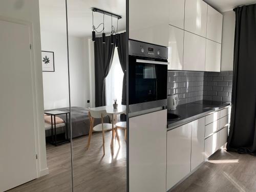 a kitchen with white cabinets and a table in a room at Near Ozas Studio in Vilnius