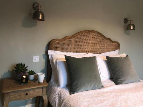 a bedroom with a bed with pillows and a table at Lovely quiet cottage Sleeps 4 adults, 4 children, Dog Friendly in Cley next the Sea
