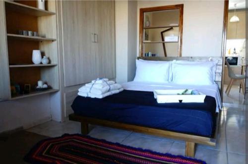 a bedroom with a large bed with blue sheets and white pillows at Havenly Loft in Mytilini