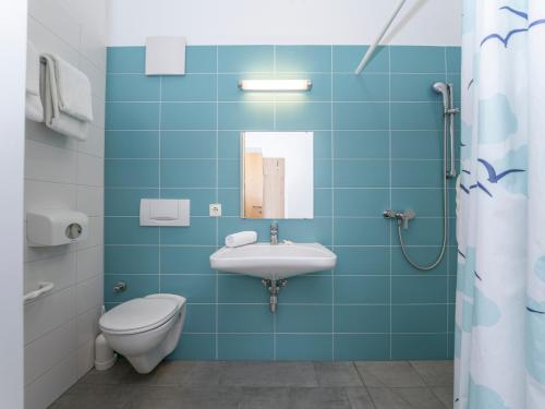 ein blaues Bad mit einem Waschbecken und einem WC in der Unterkunft Kolpinghaus Salzburg in Salzburg