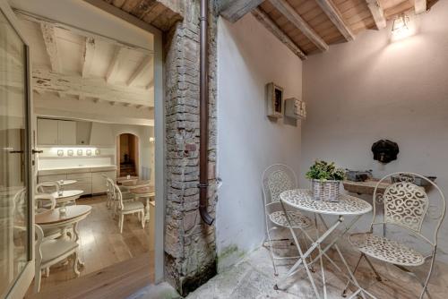 una habitación con mesas y sillas y una cocina en TORRE GIARDINO SEGRETO B&B- Borgo Capitano Collection - Albergo diffuso, en San Quirico dʼOrcia