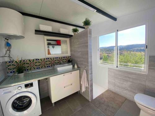 a bathroom with a washing machine and a window at Fantastic Private Villa with pool near Ardales and Caminito del Rey in Ardales