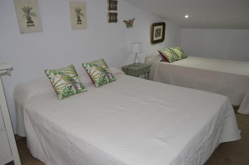 a bedroom with two white beds with pillows at Fantastic Private Villa with pool near Ardales and Caminito del Rey in Ardales