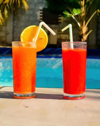 two glasses of orange juice and an orange slice on a table at Ondo House in Nungwi