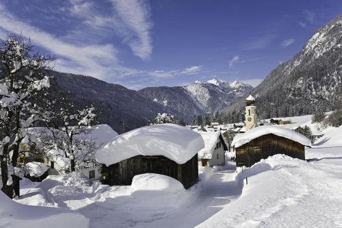 a village covered in snow with mountains in the background at Haus Sonnenhof in Wald am Arlberg