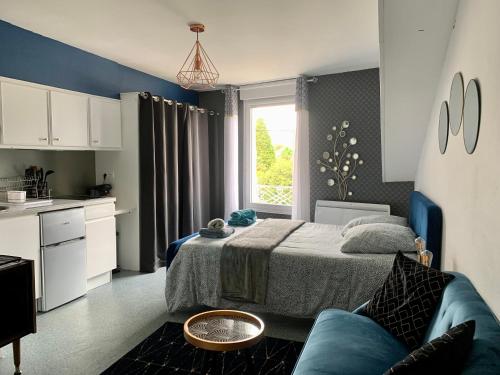 małą sypialnię z łóżkiem i kuchnią w obiekcie PYRENE HOLIDAYS Studios proches des Thermes de Bagnères-De-Bigorre et navettes ski La Mongie w mieście Bagnères-de-Bigorre