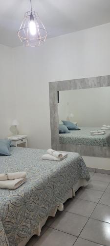 sypialnia z 2 łóżkami i dużym lustrem w obiekcie DEPARTAMENTO A&F II ALQUILER TEMPORARIO w mieście San Fernando del Valle de Catamarca