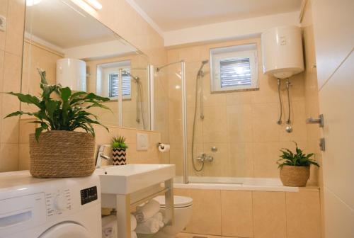 a bathroom with a toilet and a shower and a sink at Apartments Sandra in Poreč