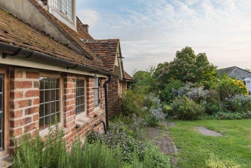an old brick house with a garden in the foreground at Moat Farm House in Ash