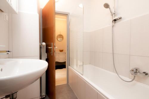 een badkamer met een wastafel en een bad bij Schickes Boutique-Apartment, zentral in Messe-& Bahnhofsnähe, sehr ruhig & gratis Parkplatz - HappyStay in Klagenfurt