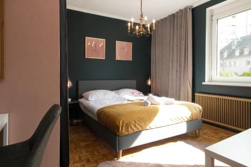 a bedroom with a bed and a table and a window at Schickes Boutique-Apartment, zentral in Messe-& Bahnhofsnähe, sehr ruhig & gratis Parkplatz - HappyStay in Klagenfurt