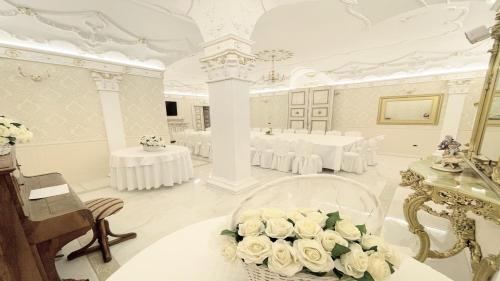 Großes Zimmer mit weißen Tischen und weißen Rosen in der Unterkunft Exclusive villa in Montefiascone -Pool and Jacuzzi in Montefiascone