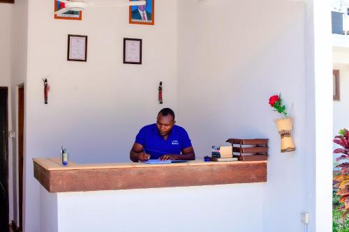 a man sitting at a counter in a room at Ondo House in Nungwi