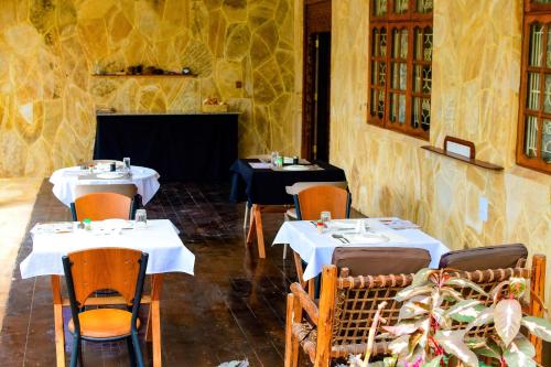 a restaurant with two tables with white tablecloths at Ondo House in Nungwi